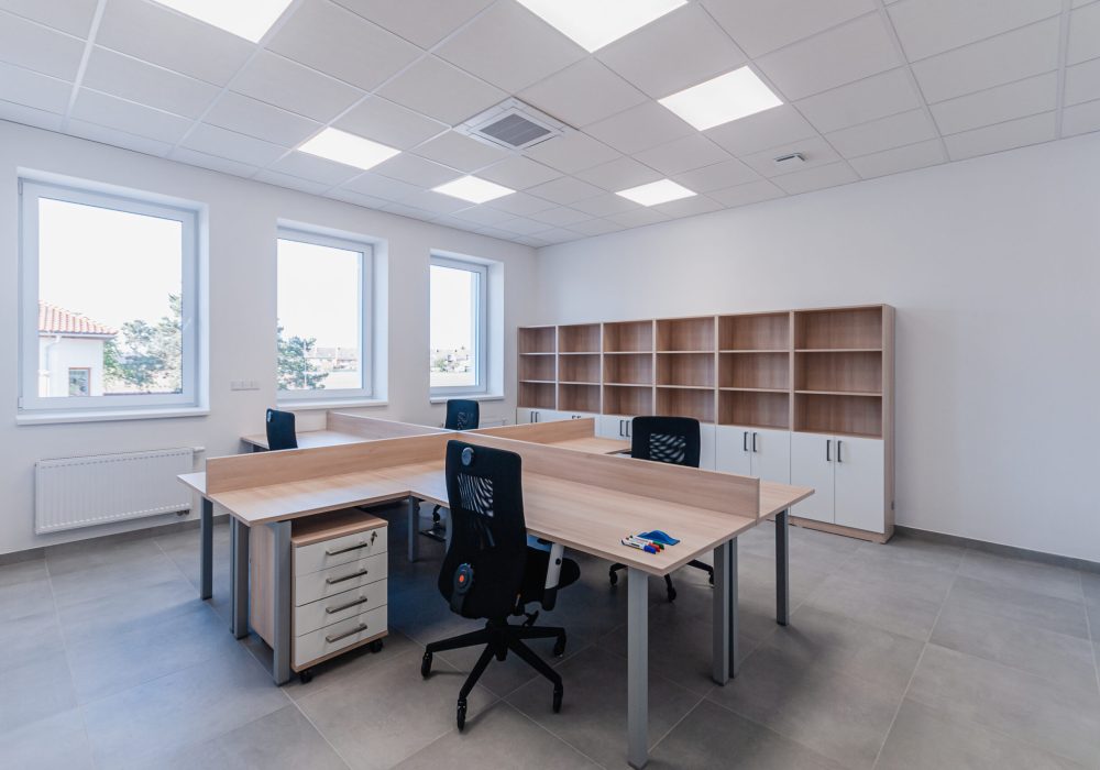 Interior of small new empty office space with desks and chairs